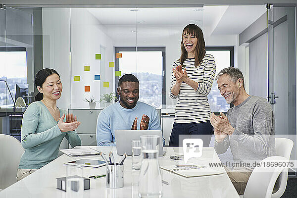 Colleagues applauding on video conference in meeting