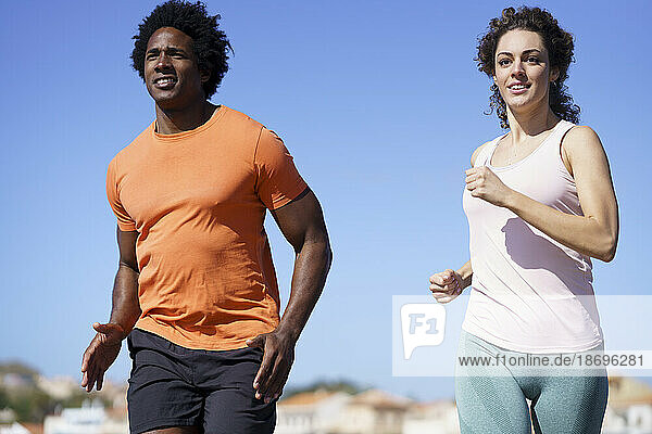 Smiling couple running in coastal area