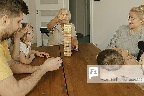 Mehrgenerationenfamilie genießt zu Hause ein Spiel am Tisch