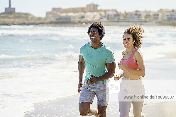 Smiling couple running at seashore