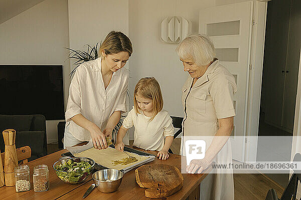 Familie hilft sich gegenseitig beim Zubereiten von Essen zu Hause