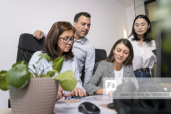 Business people working together on an architectural project in office
