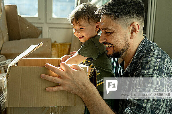 Father and son packing cardboard boxes at home