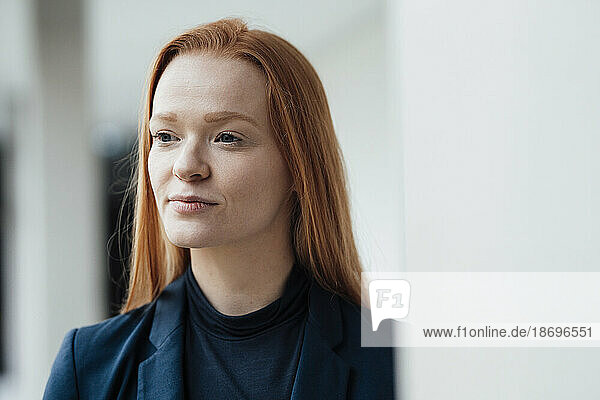 Thoughtful redhead businesswoman at office