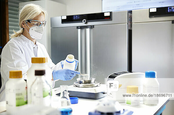 Wissenschaftler messen Chemikalien auf einer Waage im Labor
