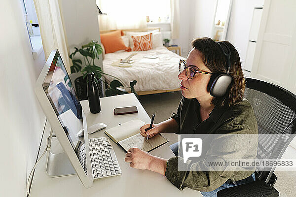 Freelancer with wireless headphones preparing strategy at home office