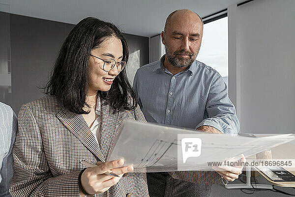Businessman and businesswoman working together on an architectural project in office
