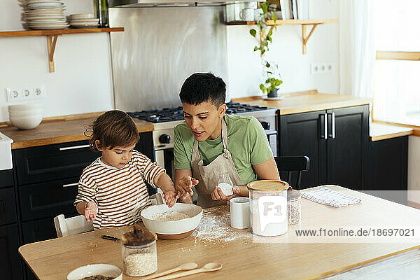 Mother and son preparing food in kitchen at home