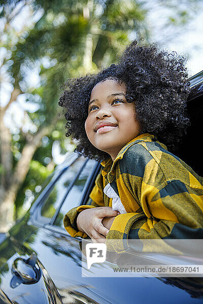 Smiling girl contemplating in car