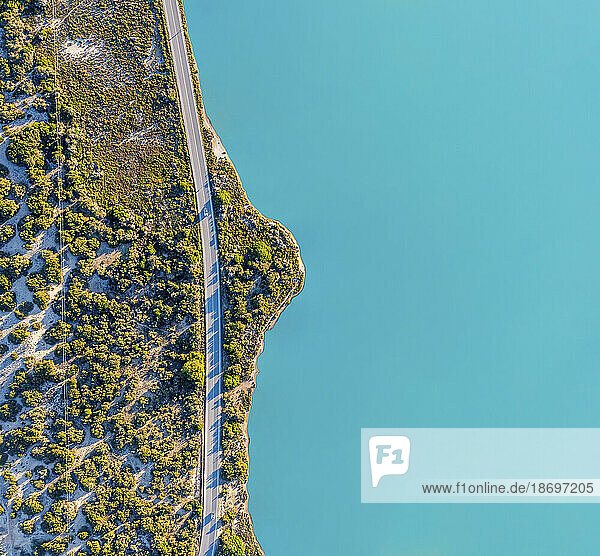 Spain  Balearic Islands  Formentera  Drone view of empty road stretching along turquoise shore