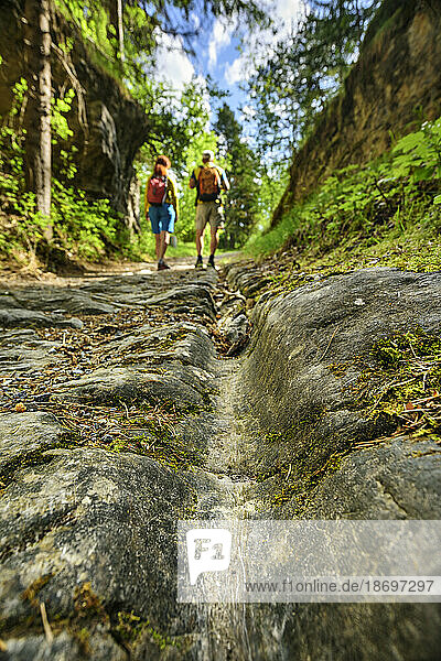 Austria  Tyrol  Hiking pair walking along ancient Roman road Via Augusta