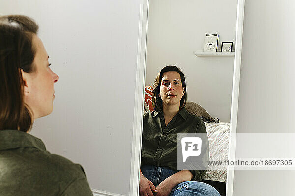 Freelancer sitting in front of mirror at home