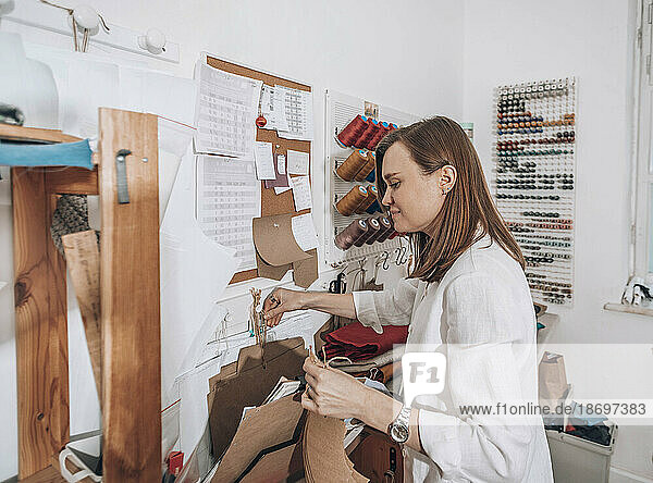 Fashion designer arranging fabric samples at workshop