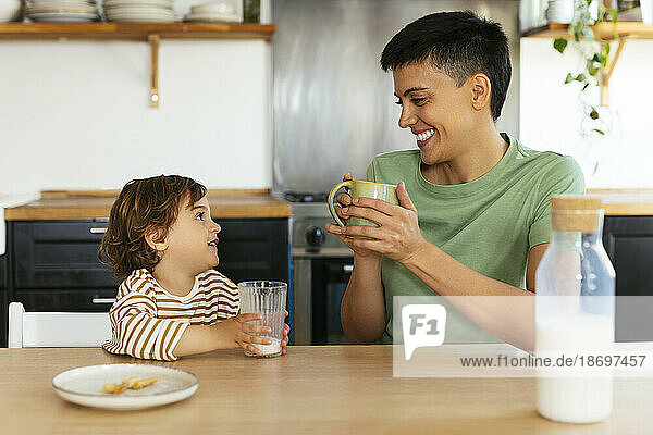Lächelnde Frau  die zu Hause mit ihrem Sohn frühstückt