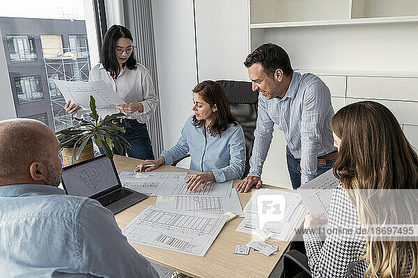 Business people working together on an architectural project in office