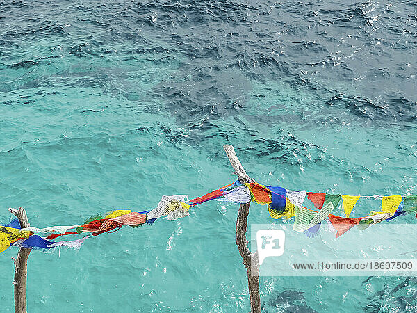 Spain  Balearic Islands  Formentera  Colorful fabrics hanging against coastal water