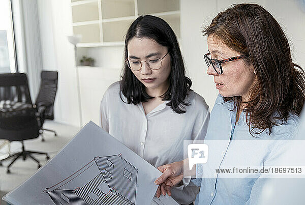 Two businesswomen working together on an architectural project in office