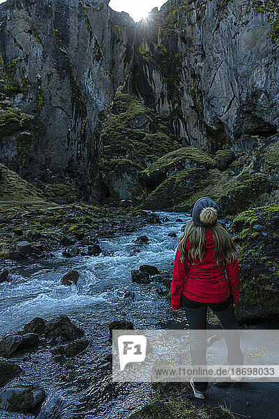 View taken from behind of a woman exploring the canyons and scenery of Thorsmork  an area of exceptional beauty in Southern Iceland; Thorsmork  South Coast  Iceland