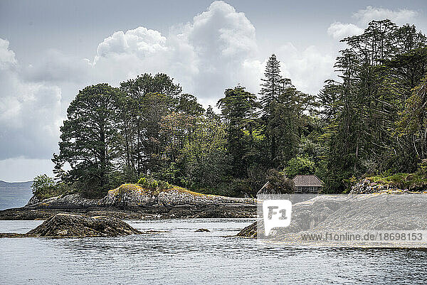 Seaside cottage amidst the woodland along the rocky shore of Garnish Island in Bantry Bay; West Cork  Ireland