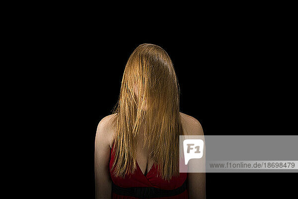 Young woman's long hair obscures her face; Lincoln  Nebraska  United States of America