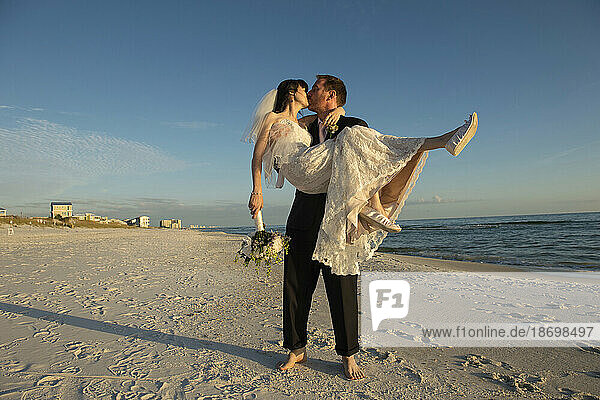 Bride and groom kiss on a beach in Florida; Panama City Beach  Florida  United States of America
