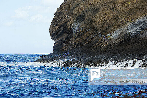 The sea  washing down the back side of the rock face of the crescent shaped  volcanic islet of Molokini in the Alalakeiki Channel off of Maui in Maui County; Maui  Hawaii  United States of America