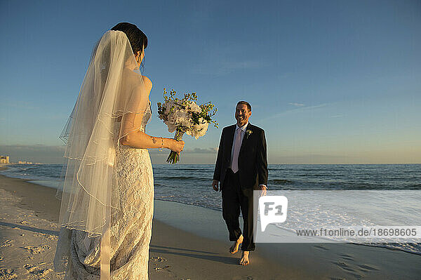 Bride and groom greet each other on a beach in Florida  USA; Panama City Beach  Florida  United States of America