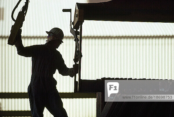 Silhouetted worker in an industrial rail yard; Wyoming  United States of America