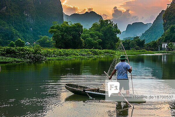 Fisherman on boat in Trang An  a scenic area near Ninh Binh  Vietnam inscribed as a UNESCO World Heritage Site in 2014
