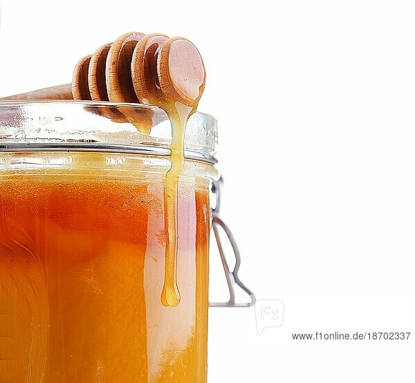 Komposition mit Stock und offenem Glas Honig