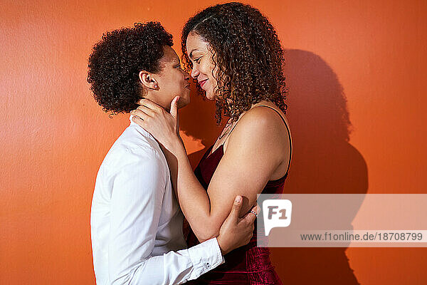 Portrait happy lesbian couple with curly hair smiling face to face