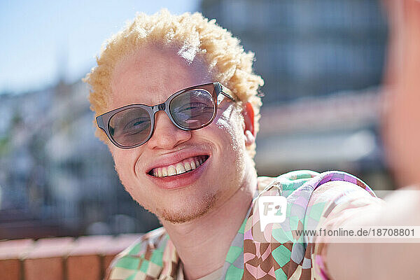 Close up selfie POV portrait happy young albino man smiling