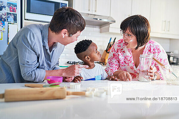 Happy lesbian couple and son baking together in kitchen
