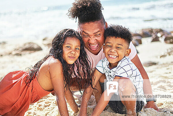 Portrait happy  playful family digging in sand on sunny summer beach
