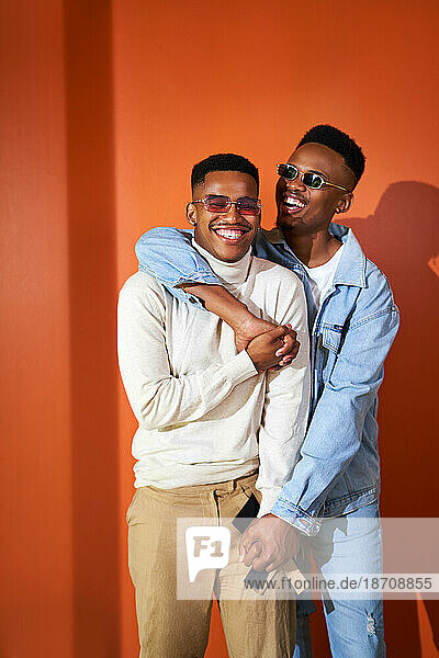 Portrait happy young gay male couple laughing and hugging