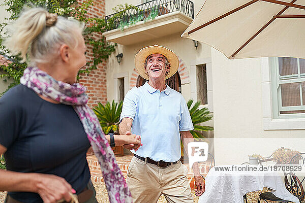 Happy  carefree senior couple dancing outside summer villa