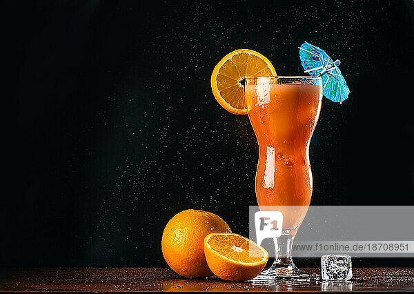 Singapore sling cocktail in tall glass against dark background