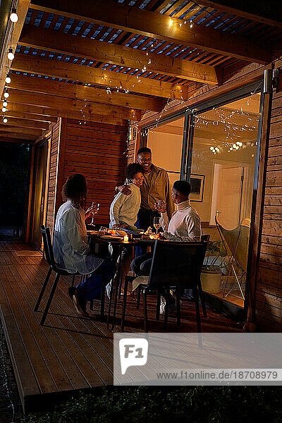 Happy couples hugging  enjoying dinner at patio table