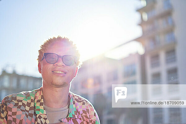 Portrait happy young man in sunny city