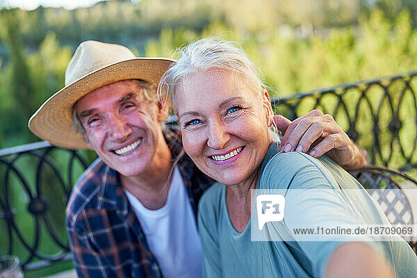Selfie POV portrait happy senior couple on summer balcony