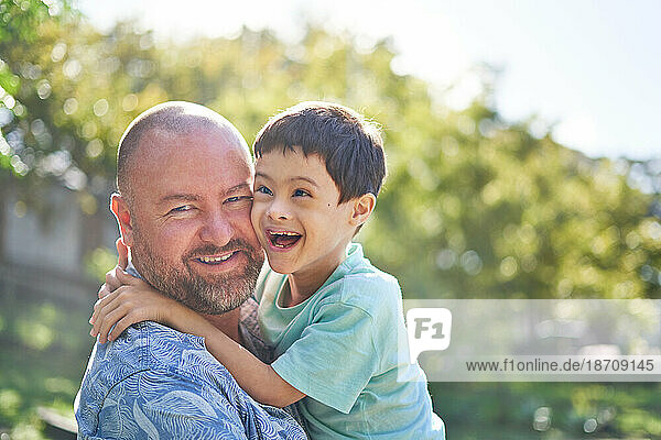 Portrait happy father holding cute son with Down Syndrome