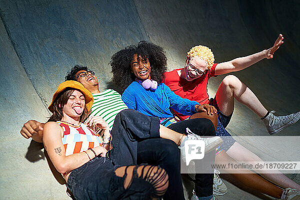 Portrait happy  carefree young friends laughing on sports ramp
