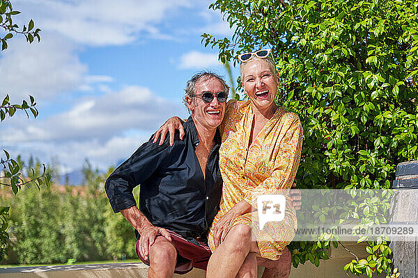 Portrait happy  carefree senior couple laughing on sunny summer patio