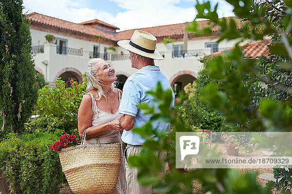 Happy  affectionate senior couple talking in villa garden