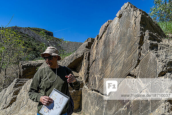 Archaeologist pointing at Rock Art  Vale de Coa  UNESCO World Heritage Site  Portugal  Europe