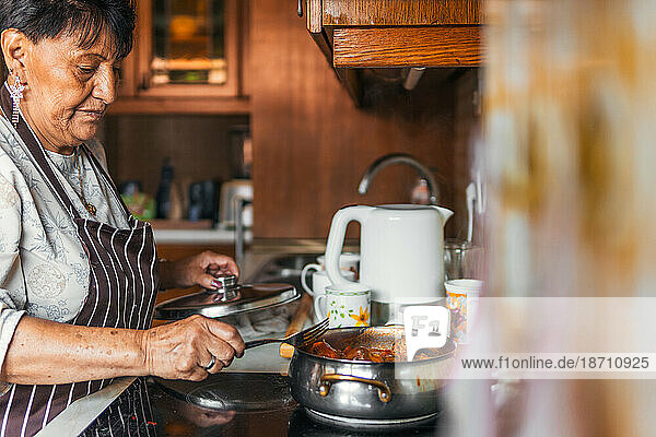 Older Latin american immigrant Woman Cooking Meatballs