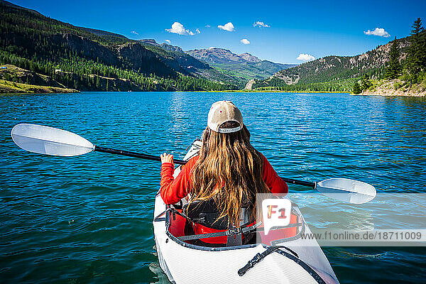 Woman Kayaking the blue waters of Lake San Cristobal