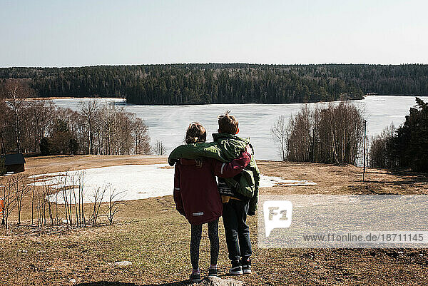 Brother and sister enjoying the beautiful lake view in Sweden