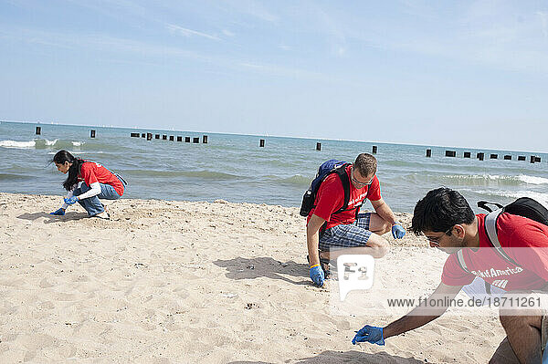 Volunteers from Bank of America pick up trash on the beach during the International Coastal Clean Up effort at North Ave. Beach in downtown Chicago.