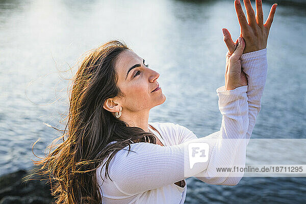 Young Woman doing Yoga on the rocks at Golden Hour
